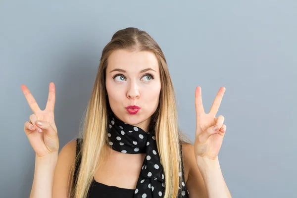 Junge Frau gibt das Friedenszeichen — Stockfoto