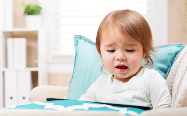 Surprised toddler girl watching her tablet computer — Stock Photo, Image