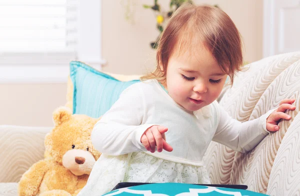 Menina criança feliz assistindo seu computador tablet — Fotografia de Stock