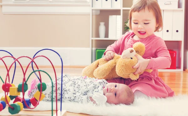 Kleuter meisje spelen met haar broer of zus van de baby — Stockfoto