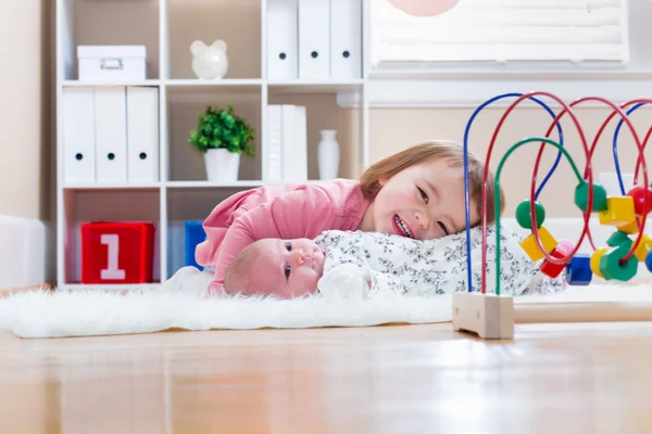 Onun bebek kardeşi ile oynarken yürümeye başlayan çocuk kız — Stok fotoğraf