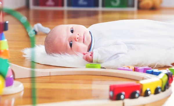 Noworodka dziewczynka leżąc w jej domu z zabawkami — Zdjęcie stockowe