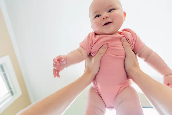 Infant baby girl being held up in the air — Stock Photo, Image