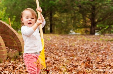Sonbahar yapraklarıyla oynayan kız