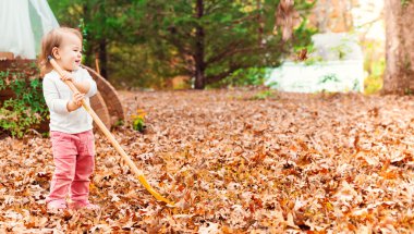 Sonbahar yapraklarıyla oynayan kız