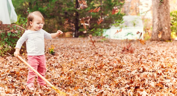 Mädchen spielt in Herbstblättern — Stockfoto
