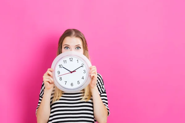 Mujer joven sosteniendo reloj — Foto de Stock