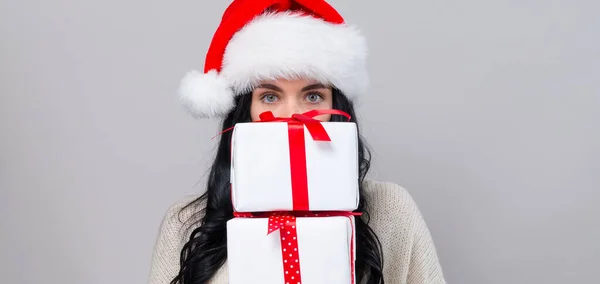 Mujer joven con sombrero de santa celebración de cajas de regalo — Foto de Stock