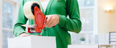 Kargoya verilecek kutuları toplayan genç kadın