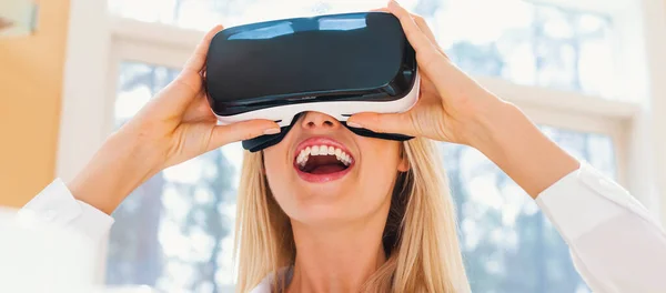 Felice giovane donna utilizzando un auricolare VR — Foto Stock