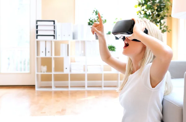 Щаслива молода жінка використовує гарнітуру VR — стокове фото