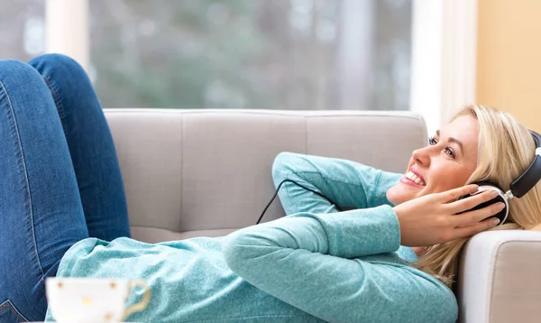 Happy young woman listening to music on headphones — Stock Photo, Image