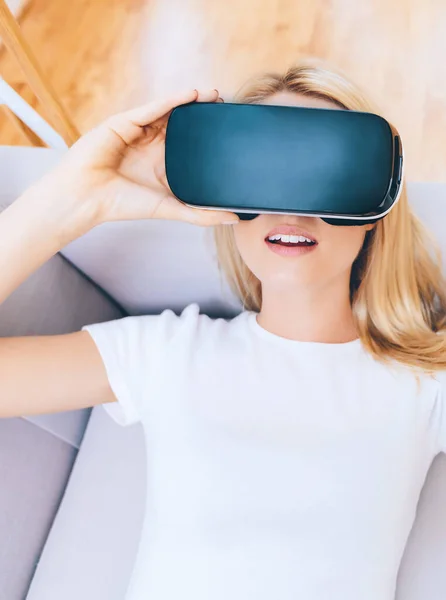 Felice giovane donna utilizzando un auricolare VR — Foto Stock