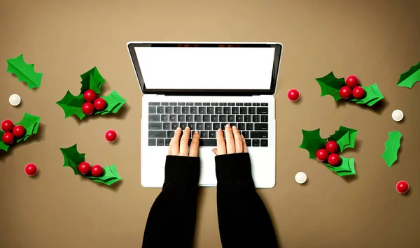 Πρόσωπο που χρησιμοποιεί φορητό υπολογιστή με Χριστουγεννιάτικα μούρα — Φωτογραφία Αρχείου