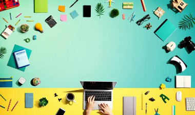 Ofis malzemesi olan bir dizüstü bilgisayar kullanan kişi.