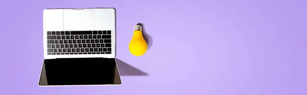 Computer portatile con lampadina gialla — Foto Stock