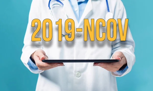 Тема 2019-NCOV з лікарем за допомогою планшетного ПК — стокове фото