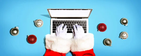Άγιος Βασίλης χρησιμοποιώντας ένα φορητό υπολογιστή με μπιχλιμπίδια Χριστούγεννα — Φωτογραφία Αρχείου