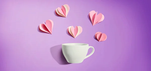 Koffiebeker met papieren ambachtelijke harten — Stockfoto