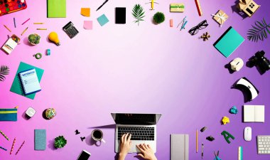 Ofis malzemesi olan bir dizüstü bilgisayar kullanan kişi.