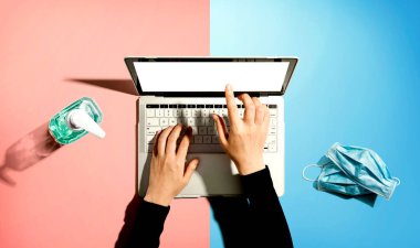 El dezenfektanı ve maskeli dizüstü bilgisayar.