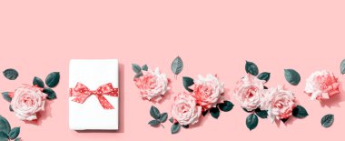 Üstünde pembe güller olan hediye kutusu.