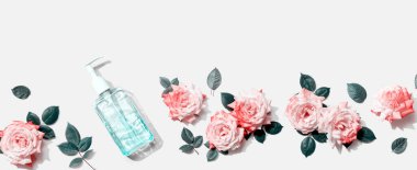 Üstünde pembe güller olan dezenfektan şişesi.