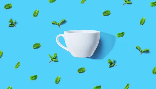 Frische Minzen mit Teetasse über Kopf — Stockfoto