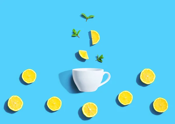 Čerstvé žluté citrony s čajovým hrníčkem nad hlavou — Stock fotografie
