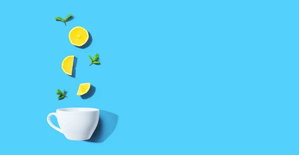 Свіжі жовті лимони з чашкою чаю вид зверху — стокове фото