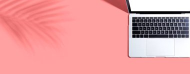 Tropikal yaprağın gölgesinde dizüstü bilgisayar