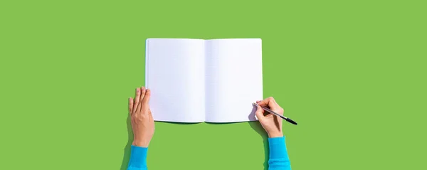 Pessoa escrevendo em um caderno — Fotografia de Stock