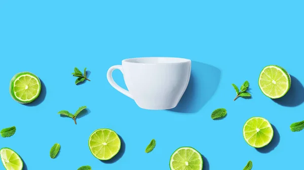 Frische Limetten mit Teetasse über Kopf — Stockfoto