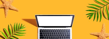 Yaz palmiyeleri ve deniz yıldızlı dizüstü bilgisayar