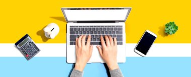 Kumbarası olan dizüstü bilgisayar kullanan bir kadın.