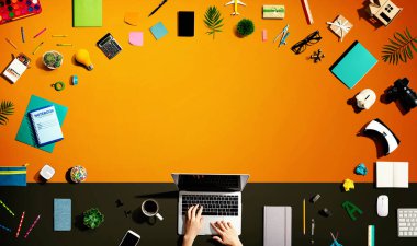 Ofis malzemesi olan bir dizüstü bilgisayar kullanan kişi.