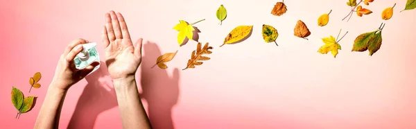 Aplicación de gel desinfectante con hojas de otoño — Foto de Stock