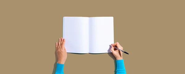 Persona escribiendo en un cuaderno — Foto de Stock