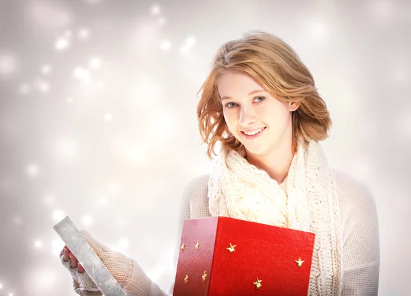 Happy young woman opening a big red gift box — Stock Photo, Image