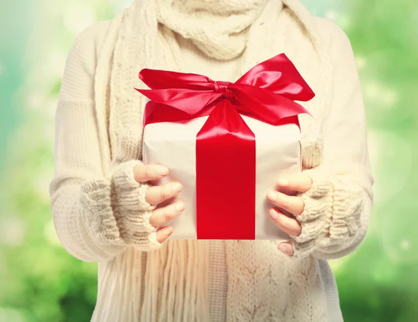 Mujer en ropa de invierno sosteniendo una caja regalo — Foto de Stock