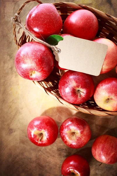 Rote Äpfel mit Anhänger im Korb — Stockfoto