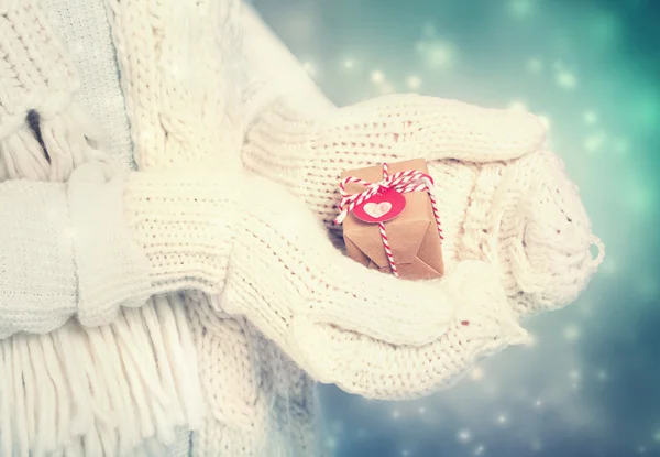 Piccola confezione regalo nelle mani delle donne con guanti bianchi — Foto Stock