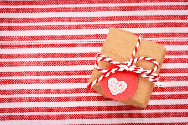 Little gift box with heart shaped tag — Stock Photo, Image