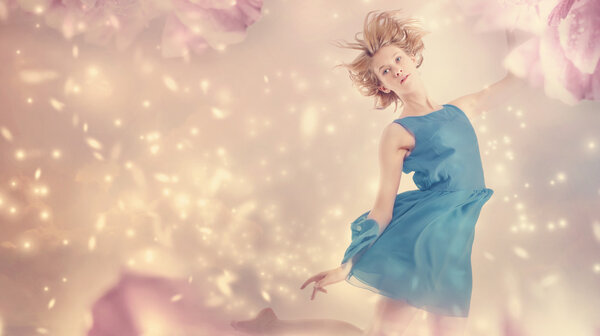 Beautiful woman in a blue dress in a pink peony flower fantasy