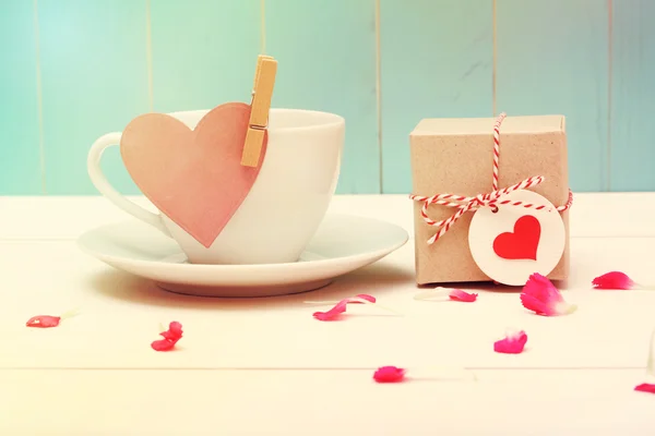Xícara de café com etiqueta de coração e uma pequena caixa de presente — Fotografia de Stock