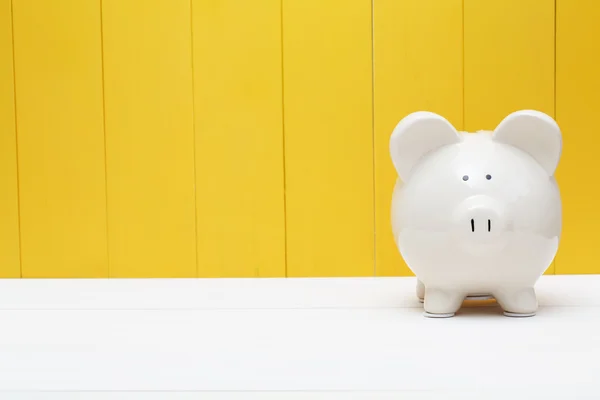 Piggy bank against a yellow wall — Stock Photo, Image