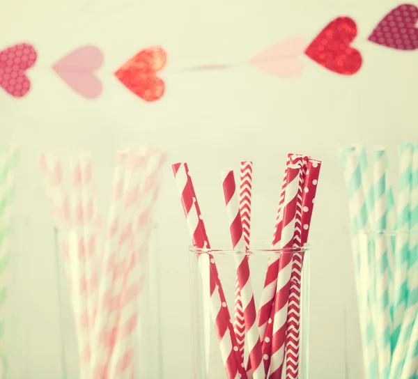 Pajitas de papel de colores con una guirnalda de corazones — Foto de Stock