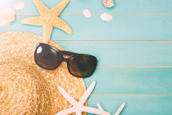 Солнечные очки с морской раковиной и соломенной шляпой — стоковое фото