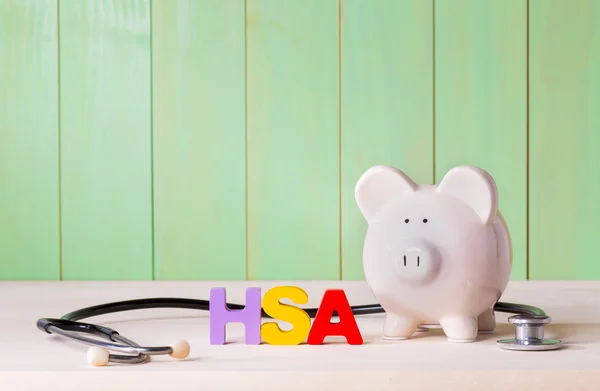 HSA téma a nyomtatott betűkkel, sztetoszkóp, és a piggy bank — Stock Fotó