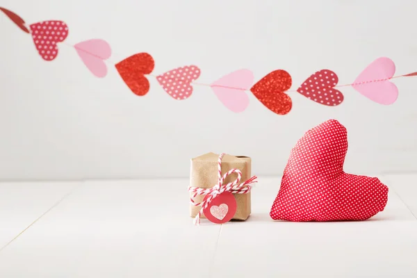 Garland van hart boven kleine geschenkdoos en hart kussen — Stockfoto